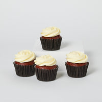 A set of four red velvet cupcakes with cream cheese icing